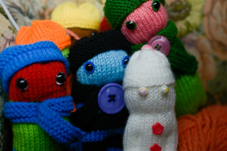 A close-up of vibrant, knitted dolls with expressive button eyes for whimsical decor.